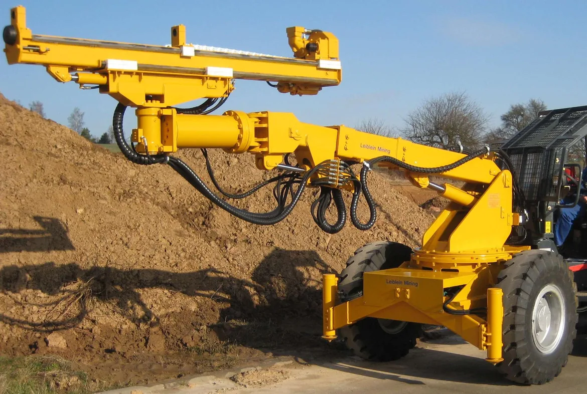 Drilling rig boom positioning with rotary actuator